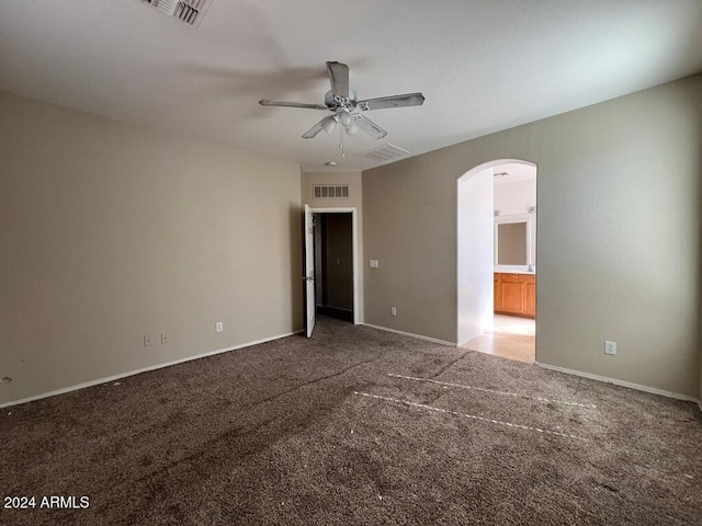 3030 S 102nd Ln, Tolleson, AZ 85353 - unfurnished bedroom featuring arched walkways, carpet flooring, a ceiling fan, and ensuite bath