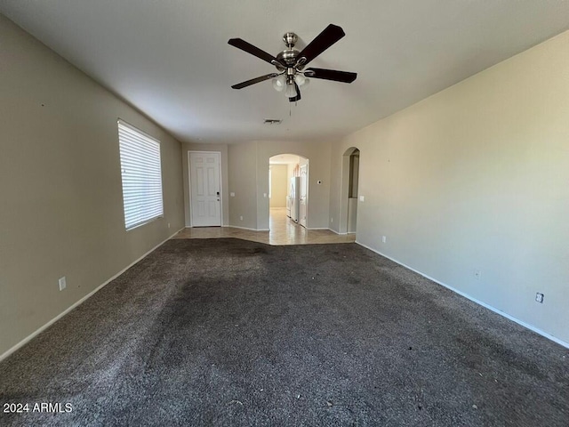 3030 S 102nd Ln, Tolleson, AZ 85353 - unfurnished living room with arched walkways, ceiling fan, and carpet flooring