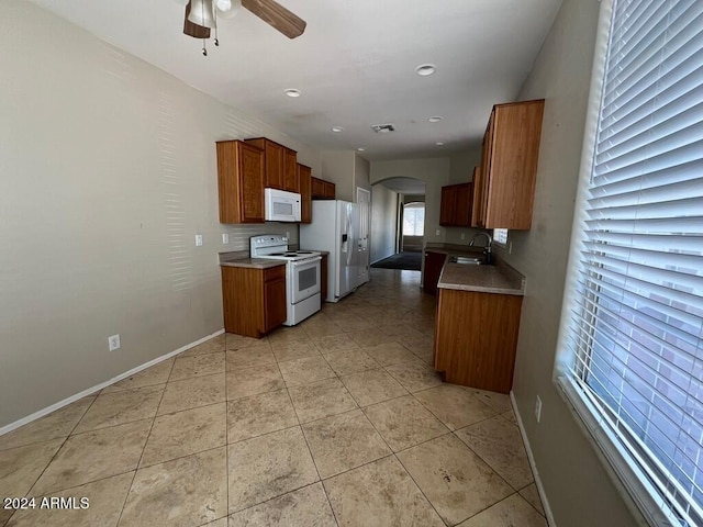3030 S 102nd Ln, Tolleson, AZ 85353 - kitchen with white appliances, arched walkways, ceiling fan, and brown cabinetry