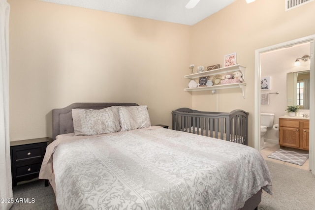 bedroom with light carpet and ensuite bath