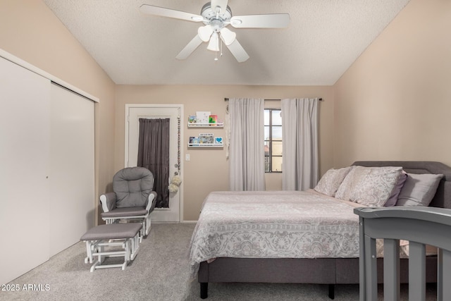 bedroom featuring lofted ceiling, a closet, a textured ceiling, and carpet flooring