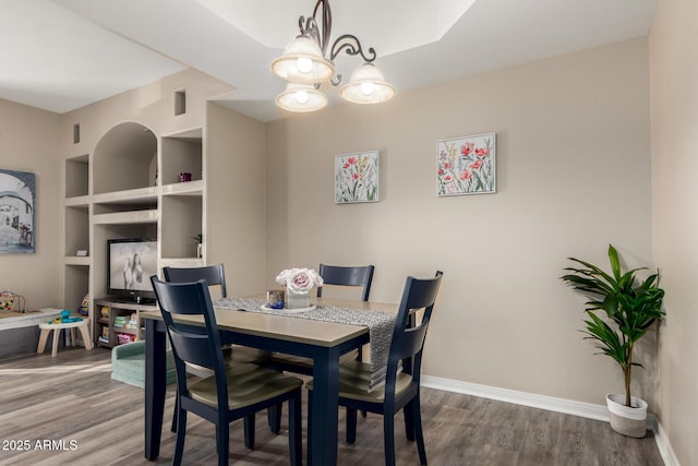 dining area featuring hardwood / wood-style flooring and a chandelier