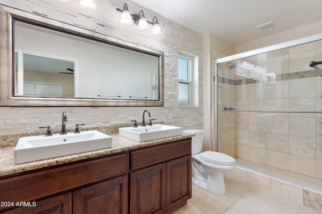 bathroom with vanity, toilet, tasteful backsplash, tile patterned flooring, and a shower with door