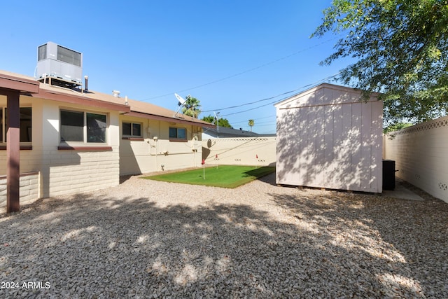 view of yard featuring a storage shed and central air condition unit