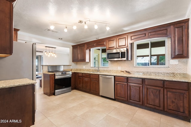 kitchen featuring decorative backsplash, pendant lighting, sink, stainless steel appliances, and ornamental molding