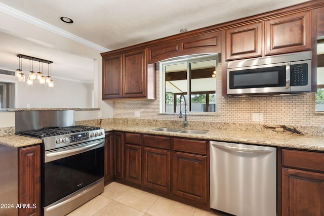 kitchen featuring light stone counters, pendant lighting, sink, stainless steel appliances, and crown molding