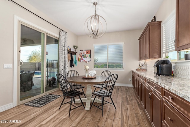 dining area with an inviting chandelier and light hardwood / wood-style flooring