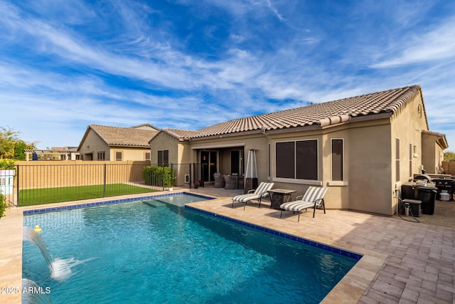 rear view of house featuring a fenced in pool, pool water feature, and a patio area