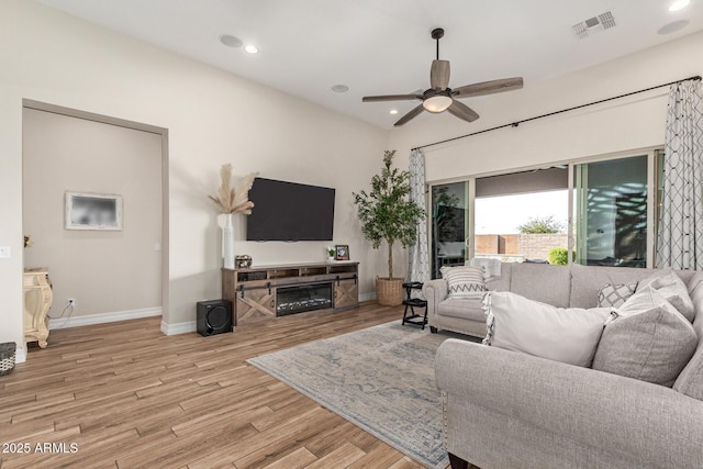 living room with ceiling fan and light hardwood / wood-style flooring