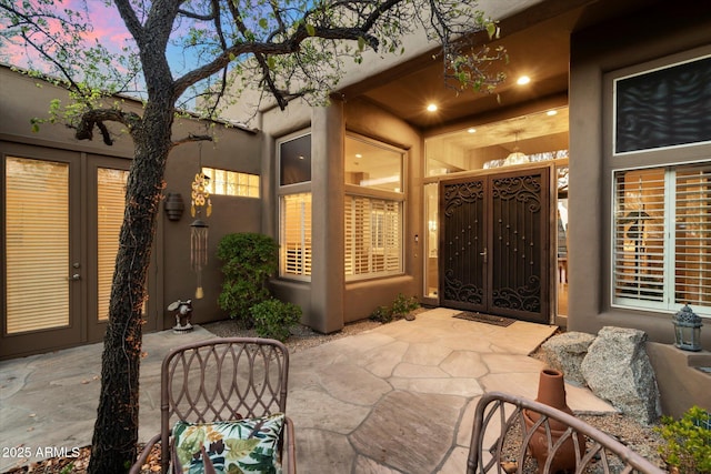 patio terrace at dusk featuring french doors