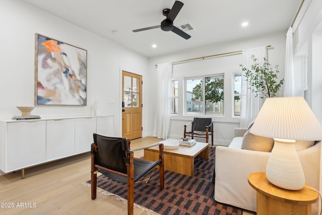 living area featuring light hardwood / wood-style flooring and ceiling fan