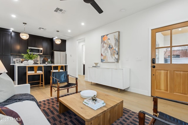 living room featuring ceiling fan and light wood-type flooring