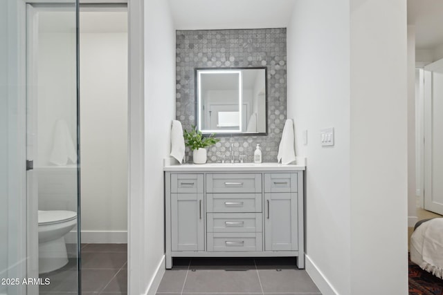 bathroom featuring tasteful backsplash, tile patterned floors, toilet, and vanity