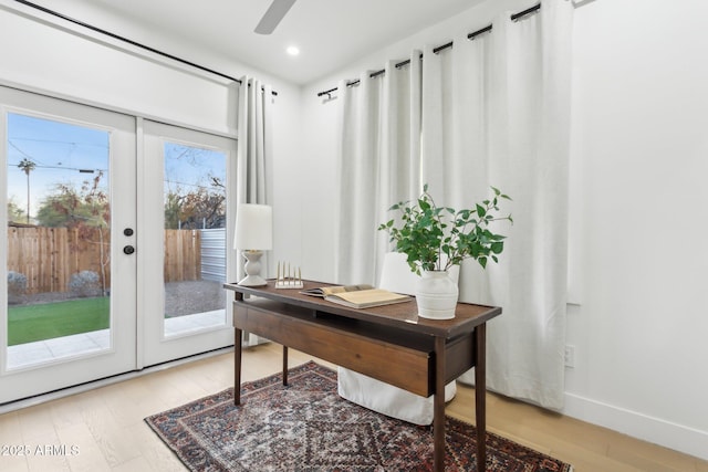 home office featuring hardwood / wood-style floors, ceiling fan, and french doors