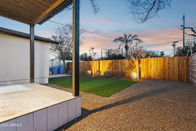 yard at dusk featuring a patio area