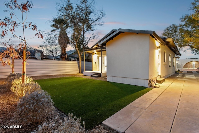 yard at dusk featuring a patio area