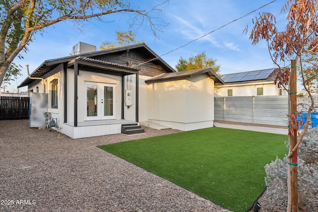 rear view of house with a yard and french doors