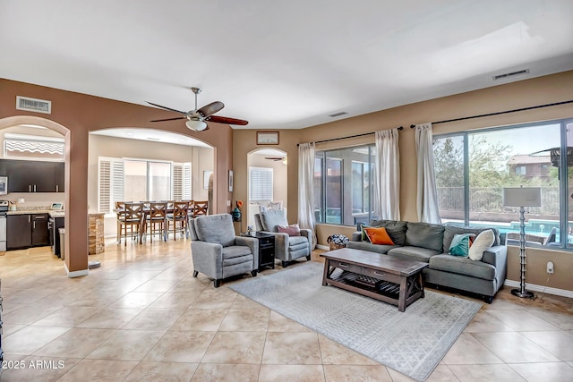 17493 W Arroyo Way, Goodyear, AZ 85338 - living area featuring arched walkways, ceiling fan, and light tile patterned floors