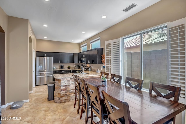 17493 W Arroyo Way, Goodyear, AZ 85338 - dining area with light tile patterned floors, recessed lighting, and arched walkways