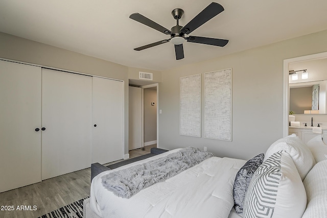 4509 E La Puente Ave, Phoenix, AZ 85044 - bedroom with wood finished floors, a closet, a ceiling fan, connected bathroom, and a sink