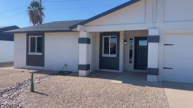 4509 E La Puente Ave, Phoenix, AZ 85044 - view of exterior entry with stucco siding, a shingled roof, and a garage
