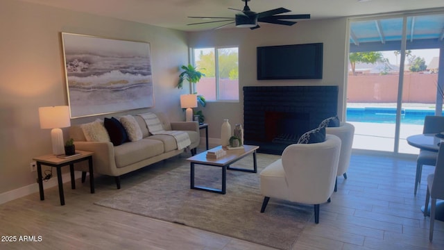 4509 E La Puente Ave, Phoenix, AZ 85044 - living room with ceiling fan, wood finished floors, a fireplace, and baseboards