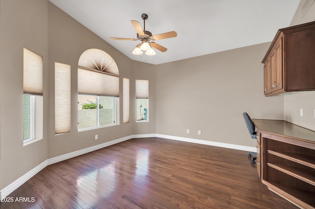 unfurnished office featuring dark wood-type flooring, ceiling fan, and vaulted ceiling