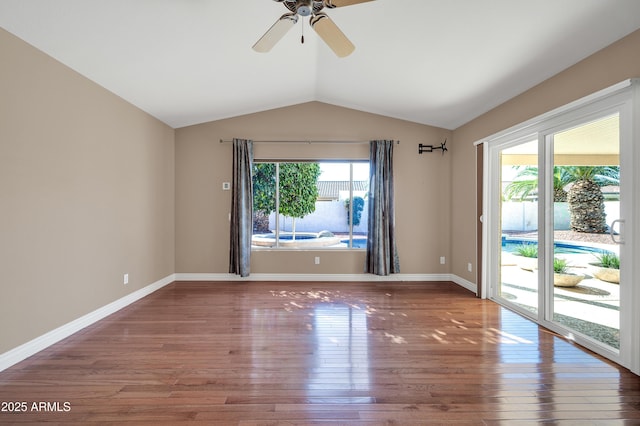 spare room featuring lofted ceiling, hardwood / wood-style flooring, a wealth of natural light, and ceiling fan