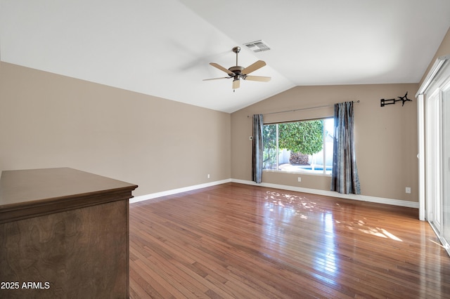 empty room featuring hardwood / wood-style floors, vaulted ceiling, and ceiling fan