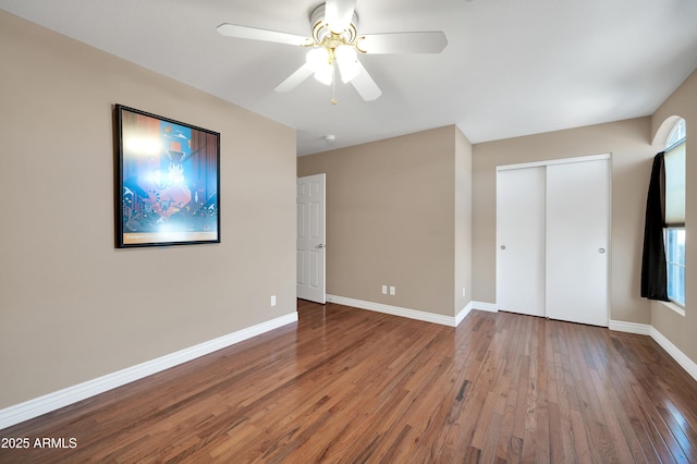 unfurnished bedroom featuring hardwood / wood-style flooring, ceiling fan, and a closet