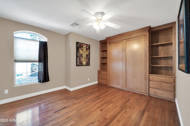 unfurnished bedroom with ceiling fan and wood-type flooring