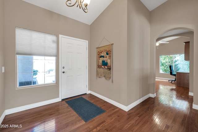 entryway with lofted ceiling, dark hardwood / wood-style floors, and a chandelier