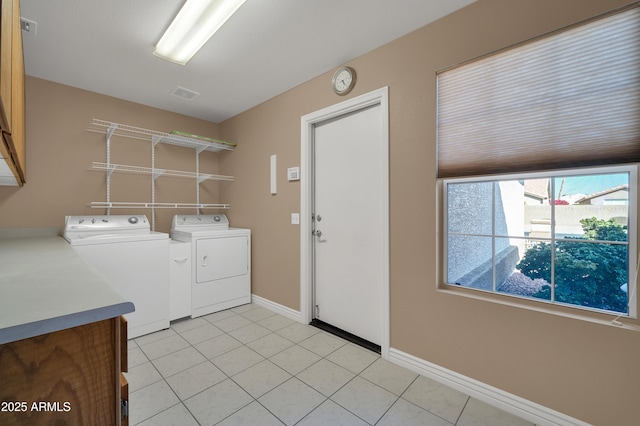 laundry area featuring independent washer and dryer, cabinets, and light tile patterned flooring