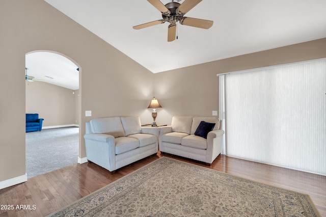 living room featuring hardwood / wood-style floors, vaulted ceiling, and ceiling fan