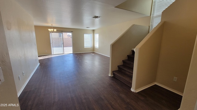 unfurnished living room featuring visible vents, dark wood finished floors, stairway, and baseboards