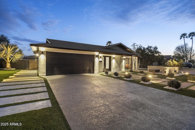 view of front of property featuring driveway, an attached garage, and stucco siding