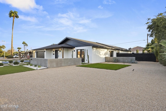 view of front of home featuring a front lawn, fence, and an attached garage