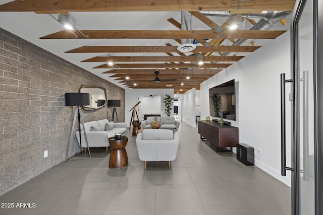 living area with brick wall, tile patterned flooring, beam ceiling, and baseboards