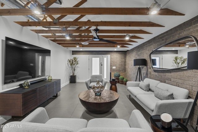 living area with brick wall, baseboards, and beam ceiling