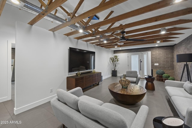 tiled living room with beam ceiling, baseboards, and brick wall