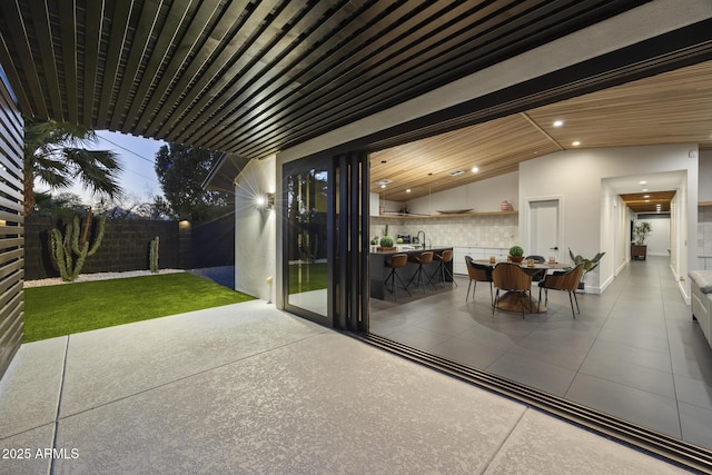 view of patio / terrace featuring fence, outdoor dining area, and a sink