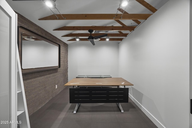 interior space featuring vaulted ceiling with beams, brick wall, and baseboards