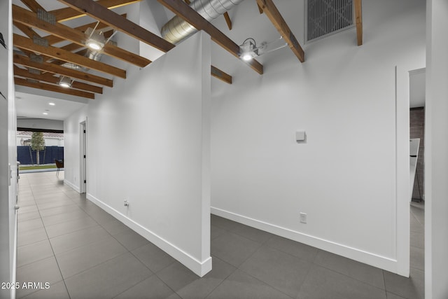 corridor featuring high vaulted ceiling, dark tile patterned floors, visible vents, baseboards, and beamed ceiling