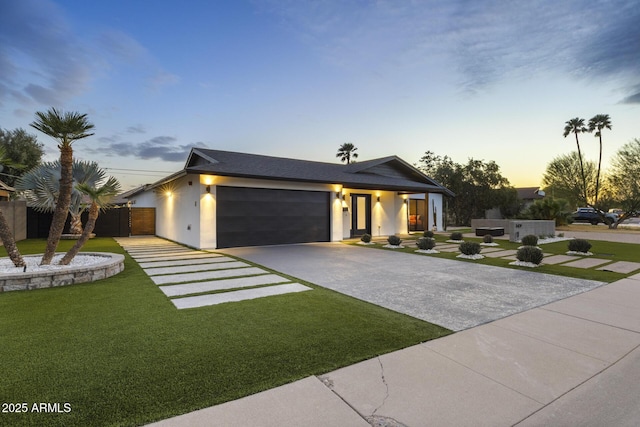 view of front facade with driveway, a front lawn, an attached garage, and stucco siding