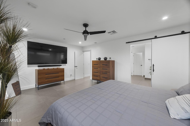 bedroom with a barn door, recessed lighting, visible vents, baseboards, and tile patterned floors