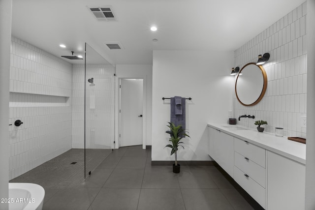 full bath with tile patterned flooring, visible vents, tile walls, and walk in shower