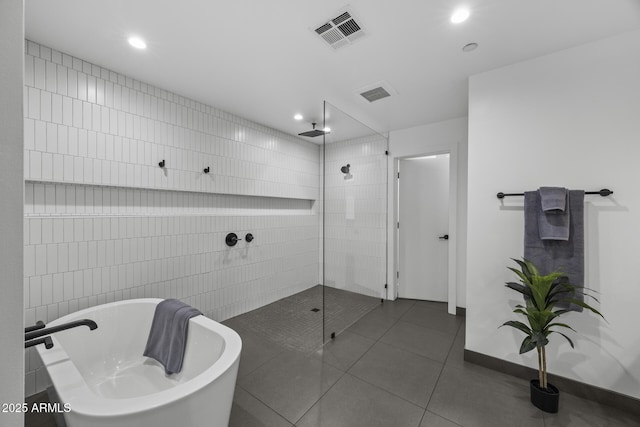 bathroom with tile patterned flooring, a soaking tub, visible vents, and a walk in shower