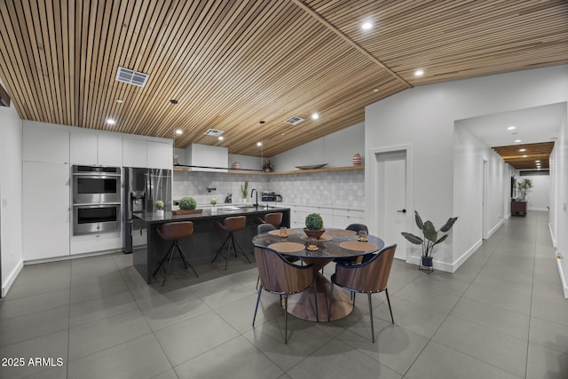 dining room with lofted ceiling, recessed lighting, dark tile patterned floors, wood ceiling, and visible vents