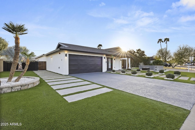 view of front of house featuring a garage, driveway, a gate, stucco siding, and a front yard