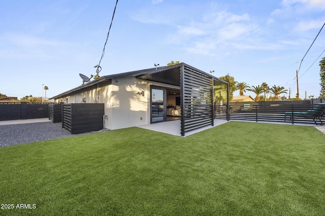 rear view of house featuring a lawn and fence